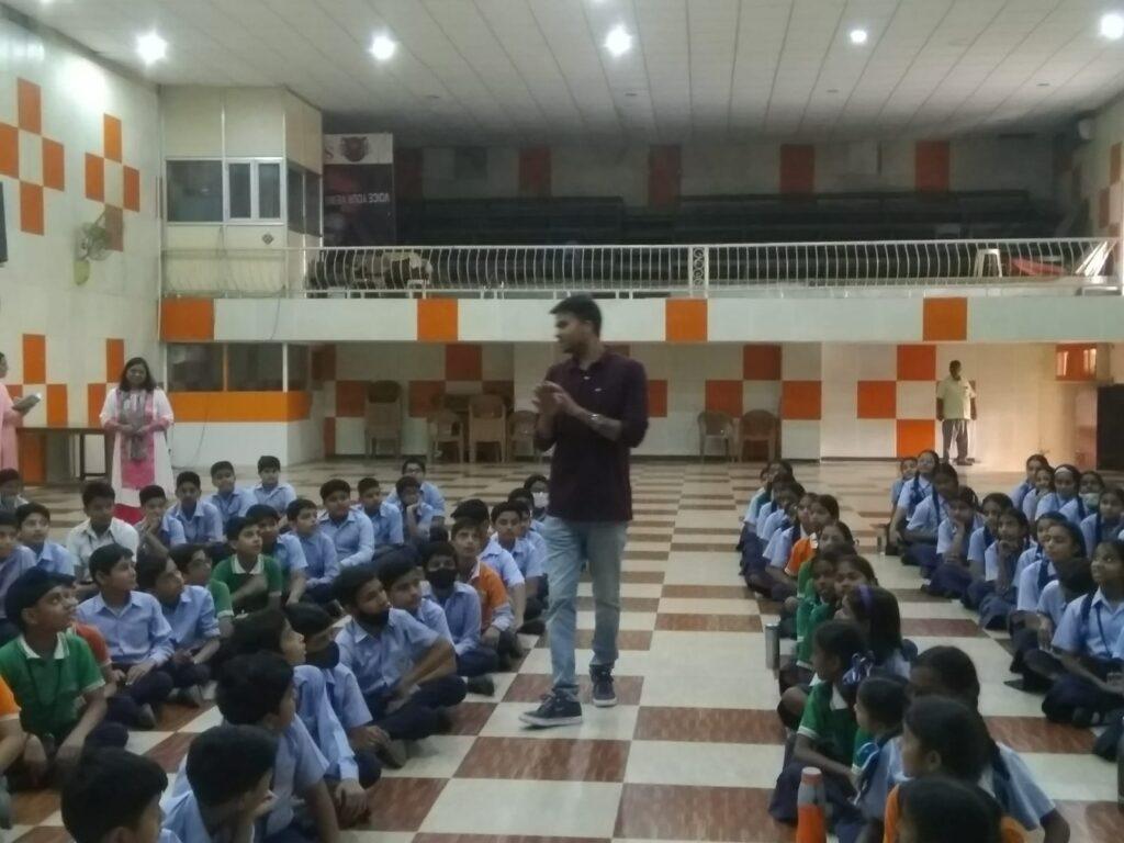 A Man demonstrating the science project to a lot of school children